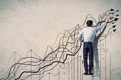 Back view image of businessman drawing graphics on wall