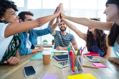 Creative business team putting hands together at the office