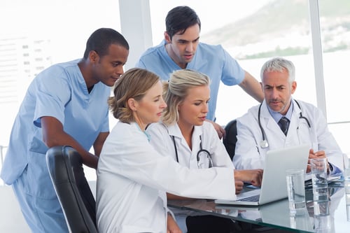 Serious medical team using a laptop in a bright office-2