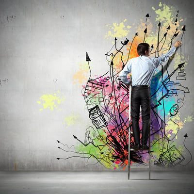 Back view of businessman drawing colorful business ideas on wall