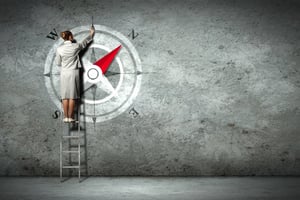 Businesswoman drawing compass with finger on wall standing on ladder-1