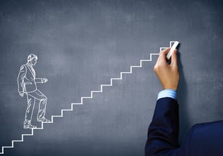 Close up of human hand drawing career ladder with chalk