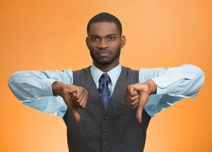 Closeup portrait unhappy, angry, mad, annoyed, grumpy man giving thumbs down gesture, looking with negative facial expression disapproval isolated orange background. Human emotion hand sign, attitude.jpeg