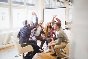 Excited creative business people giving high-five in meeting room at creative office.jpeg