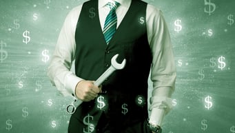 Handsome businessman holding tool with dollar symbols around and with green background