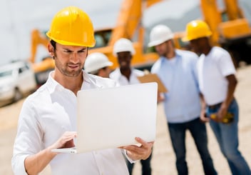 Male engineer at a construction site with a computer.jpeg