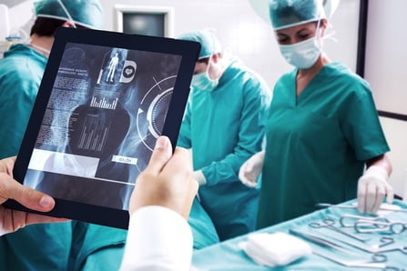 Man using tablet pc against medical interface on xray.jpeg