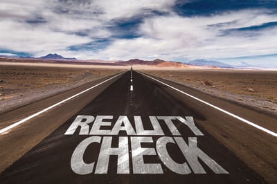 Reality Check written on desert road