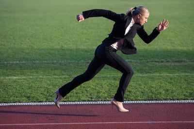 business woman in start position ready to run and sprint on athletics racing track