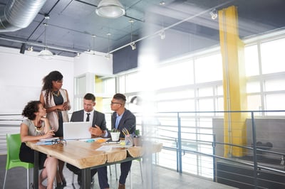 team of successful business people having a meeting in executive sunlit office